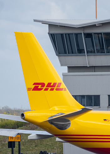 15.4.2021 DHL Cargo hub East Midlands Airport Nottingham.\nYellow Boing aircraft delivering packages freight and cargo to central distribution hub at EMA in Nottinghamshire. Control tower and planes.