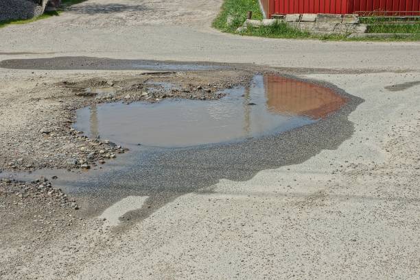 istock a large pothole with a puddle and brown muddy water 1317580496