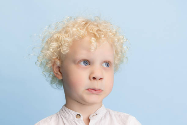 istock Close-up cute little preschool boy posing isolated over blue studio background. 1317583905