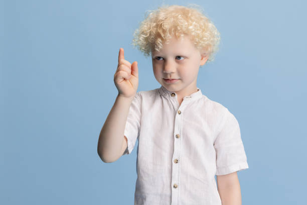 istock One cute little preschool boy posing isolated over blue studio background. 1317583909