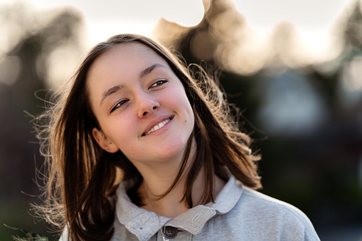 Generation Z. Close up portrait of happy smiling tween girl outdoors. Teenager girl with trendy eyes makeup, natural beauty and tenderness of youth.