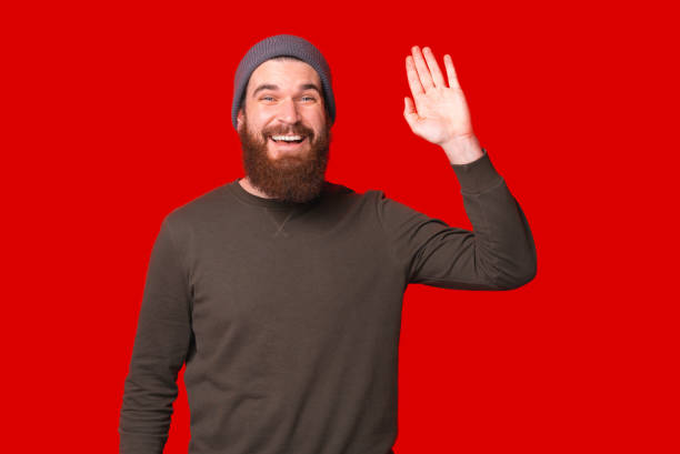 istock Joyful young happy man with beard making Hello gesture 1317584795