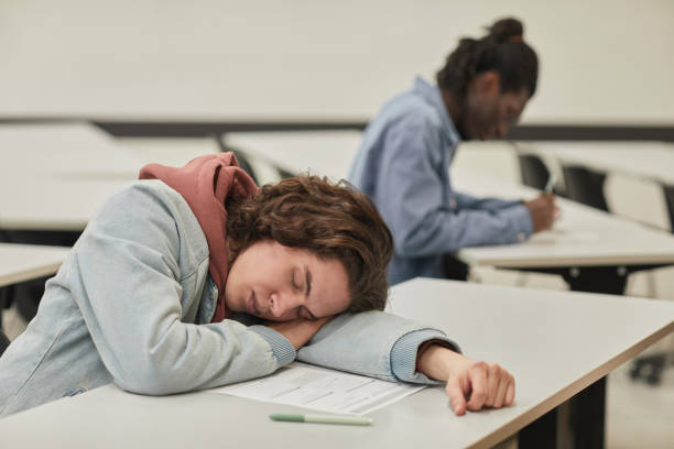 adolescente che dorme in classe - sleeping high school desk education foto e immagini stock