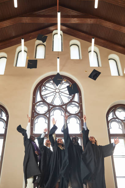istock Graduates throwing caps in air indoors 1317585031