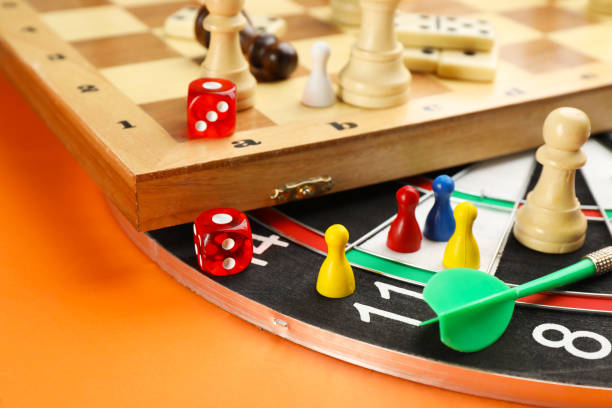 istock Different types of board games and its' components on orange background, closeup 1317587891