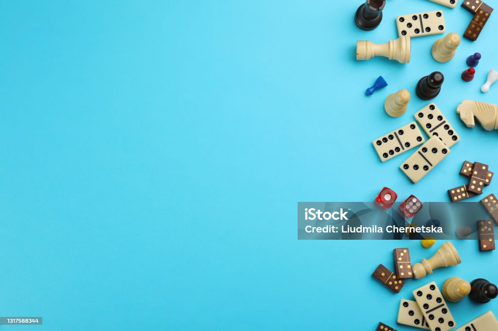 Components of board games on light blue background, flat lay. Space for text Leisure Games Stock Photo