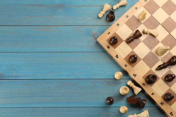 istock Flat lay composition of chess on light blue wooden table, space for text. Board game 1317589451
