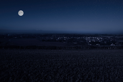 Composite image depicting a starry night sky with full moon