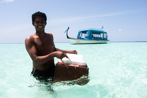 Alifu Alifu atol, Maldives - July 06, 2008: A young Chef taking food from tourist boat to prepare lunch for guests on desert island