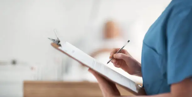 Photo of Shot of an unrecognizable nurse checking a patients medical chart