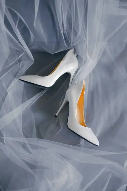 Photo of Bride's shoes with a veil top view close-up