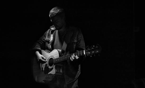 istock Male guitarist playing acoustic guitar copy space. 1317596547