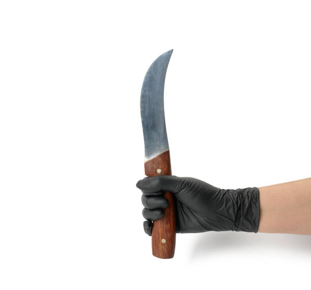 istock hand in a black latex glove holds a kitchen knife on a white background 1317598704