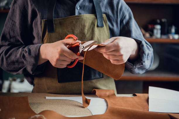 istock A young tanner in his workshop at the table cuts out leather elements of shoes 1317599842