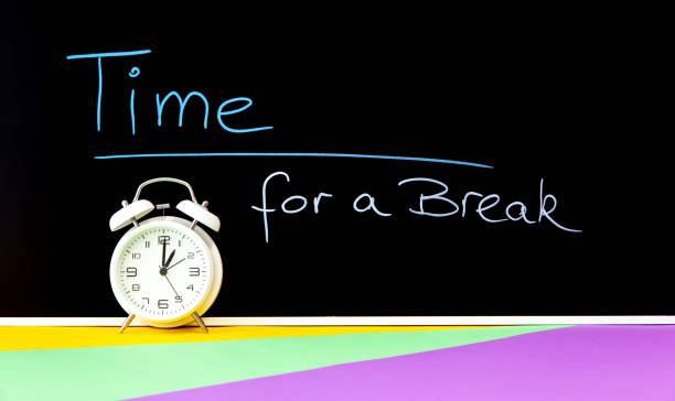 Time for a break drawing on a black chalkboard and a white clock at 13 o'clock. chalk icon. Taking a Break concept with classic alarm clock coffee break stock pictures, royalty-free photos & images