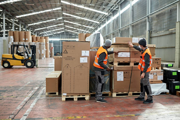 istock Workers Managing Warehouse Merchandise in Time of COVID-19 1317600205