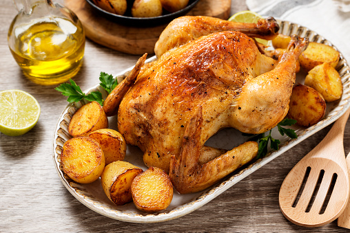 Whole roasted chicken with baked potatoes.