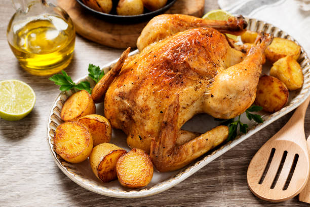 Whole roasted chicken Whole roasted chicken with baked potatoes. gold potato stock pictures, royalty-free photos & images