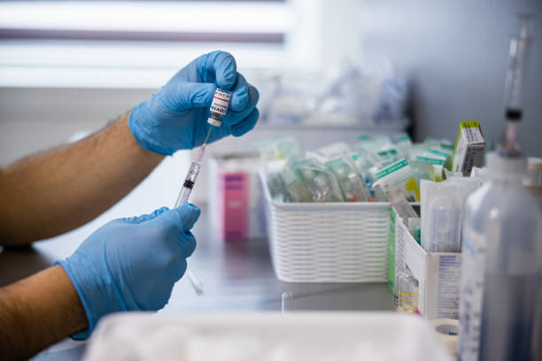 istock Holding vial and pulling out COVID-19 vaccine with syringe 1317604374
