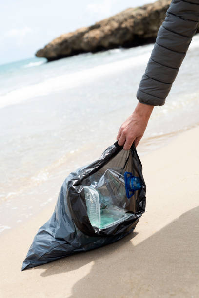 istock man with a garbage bag full of waste on a beach 1317605351