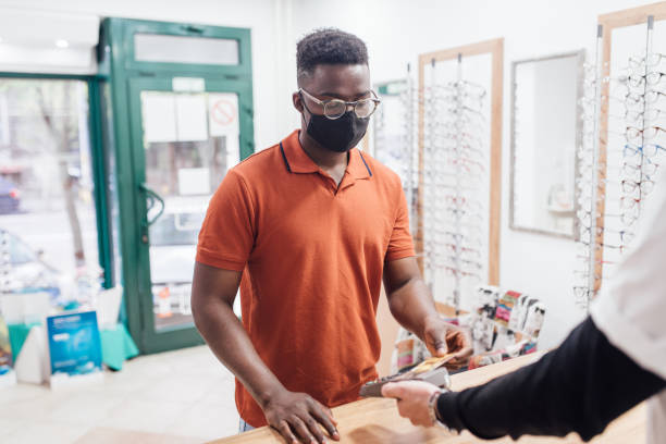 istock Young man making a payment at the optics store 1317608446