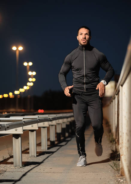 istock A young male athlete jogs at night. 1317611446