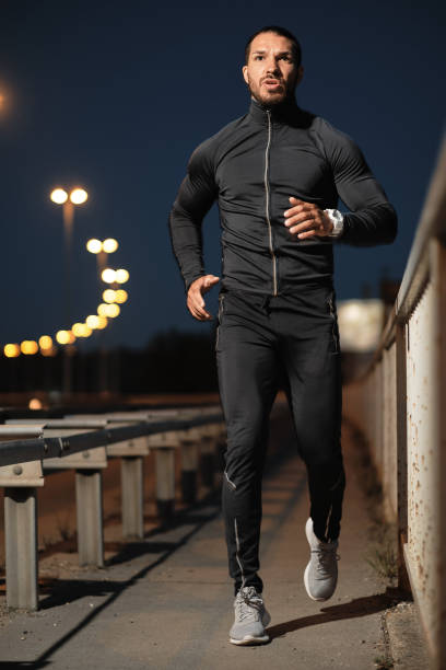 istock A young male athlete jogs at night. 1317611744