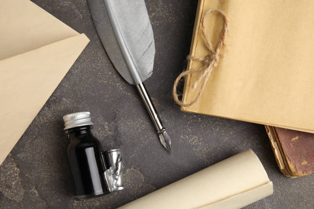 istock Flat lay composition with feather pen and bottle of ink on grey table 1317613207
