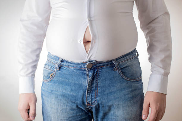 A fat man in a small, tight white shirt. Uncomfortable clothing concept, obesity. Slimming A fat man in a small, tight white shirt. Uncomfortable clothing concept, obesity. Slimming, office worker tear gas photos stock pictures, royalty-free photos & images