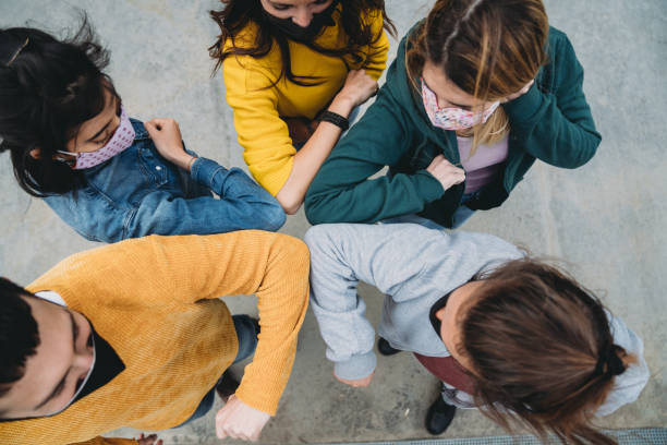 Five friends are greeting with an elbow bump all together