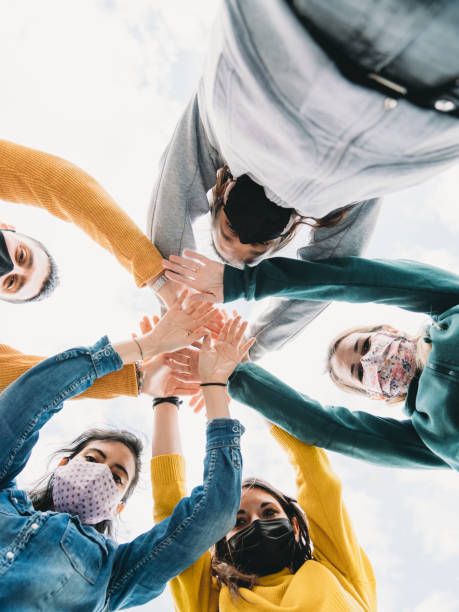 istock Millennial friends stacking hands together - View from below 1317614836