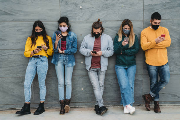 istock Friends are using a smart phone against a wall outdoor 1317614980