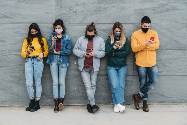 istock Friends are using a smart phone against a wall outdoor 1317614991