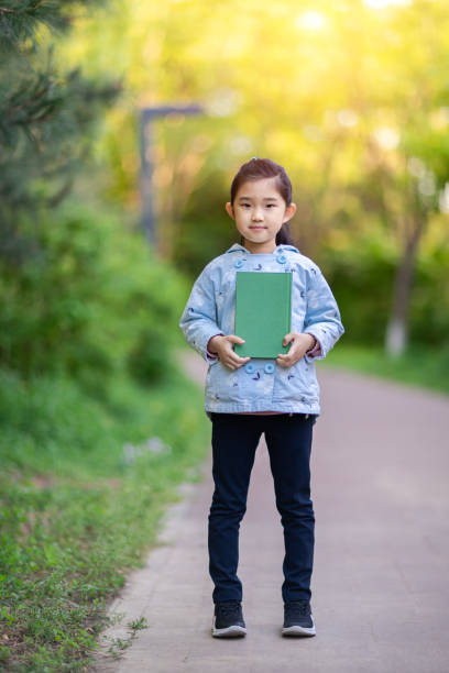 istock Little Girl Holding Book 1317615767