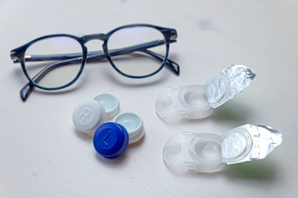 Contact lenses and glasses on a white surface. stock photo