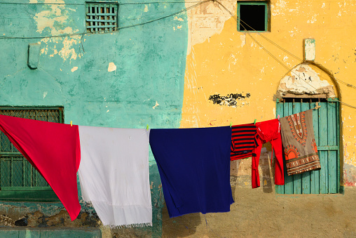 Berbera, Sahil Region, Somaliland, Somalia: green and yellow facades with laundry hanging on a clothesline - Suufi Hassan Road, Darole district.