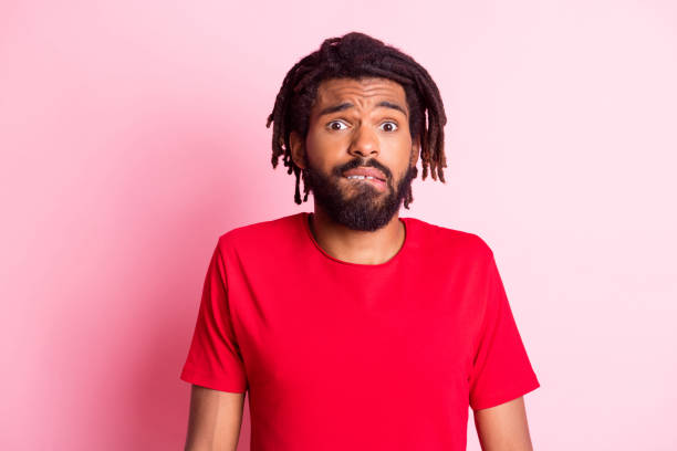 istock Photo of young afro guy unhappy bite lips teeth confused doubt questioned no answer isolated over pink color background 1317620758