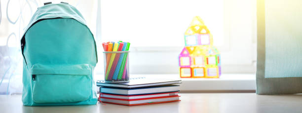 istock Banner. Concept back to school. Full turquoise School Backpack with stationery on table. 1317621225