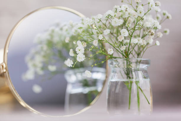 Rustic Baby"u2019s Breath Dried white gypsophila flowers and mirror on the table. Beautiful wedding decor ideas and decor interior. stock photo