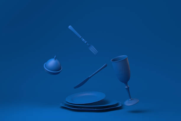 голубая пустая тарелка, вилки, ножи, ложки, установленные в ресторане, плавающие в синем фоне. минимальная концепция идея творческой. монохр - plate empty blue dishware стоковые фото и изображения