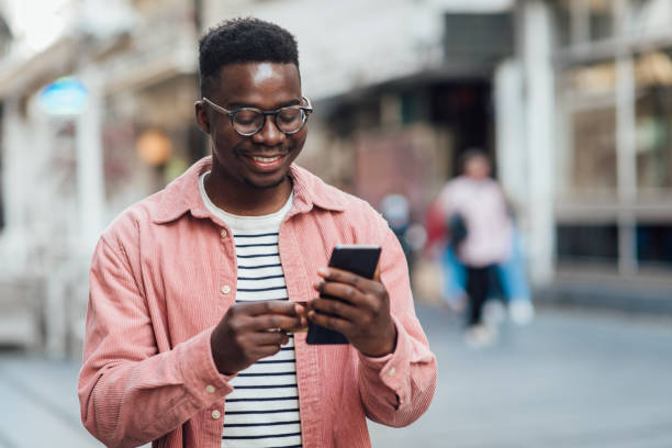 retrato de un joven feliz que paga en línea con una tarjeta de crédito - travel red vacations outdoors fotografías e imágenes de stock