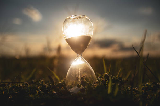 istock Life time passing concept. Hourglass at sunset time. 1317628357