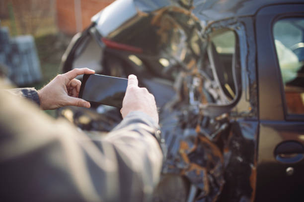 car insurance agent at work by the crashed car - car insurance insurance agent damaged imagens e fotografias de stock