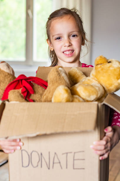 istock Girl holding donation box 1317631919
