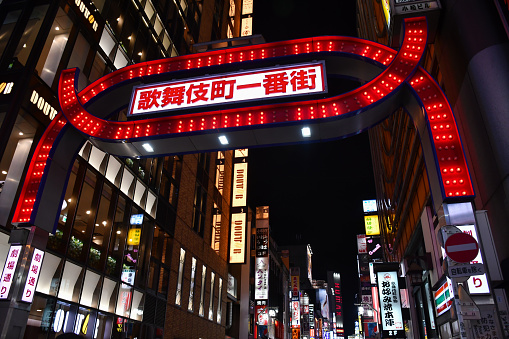 Tokyo, Japan - August 26, 2019: The red Kabukicho Ichiban-gai gate, the main entrance to the Kabukicho entertainment and red-light district in Shinjuku, lit up at night.