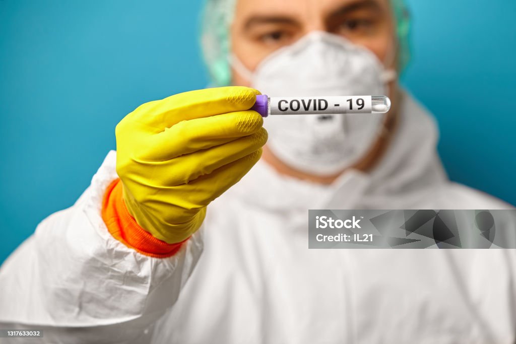 Image of doctor wearing respirator mask and protective coverall holding a express test result for the Coronavirus. Covid-19 sample. Image of doctor wearing respirator mask and protective coverall holding a express test result for the Coronavirus. Covid-19 sample. Corona virus outbreaking. Epidemic virus Respiratory Syndrome. China, Wuhan. Wuhan Stock Photo