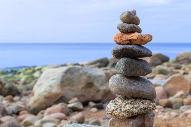istock Stones pyramid on the seashore. Sunset on pebble beach. Balanced life, relax. 1317634322