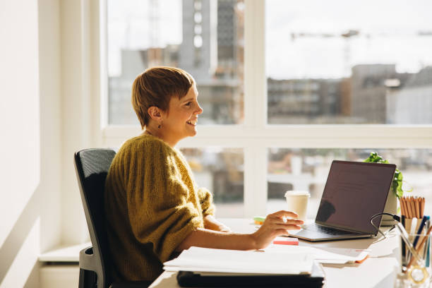 istock Woman looking away and smiling while working in office 1317634893