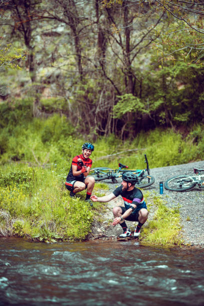 istock Cute Cyclist Couple Enjoying Resting By River During Mountain Biking Adventures 1317635722