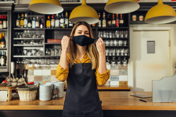 istock Woman putting face mask on in cafe 1317637015